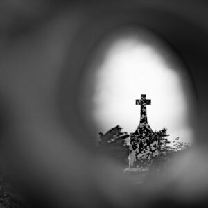 Cross silhouette seen through a blurry foreground